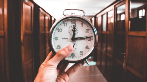 una mano che tiene una vecchia sveglia analogica